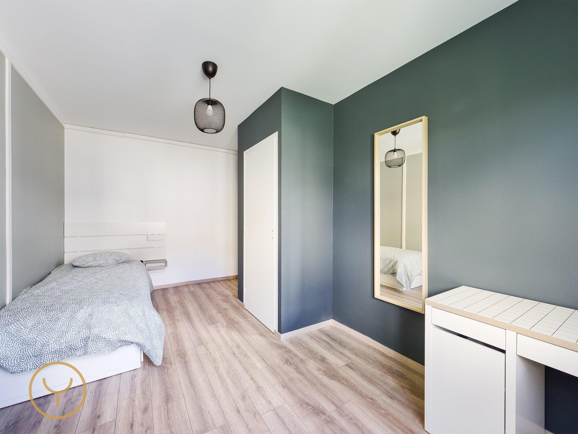 Chambre meublée avec lit, bureau et miroir